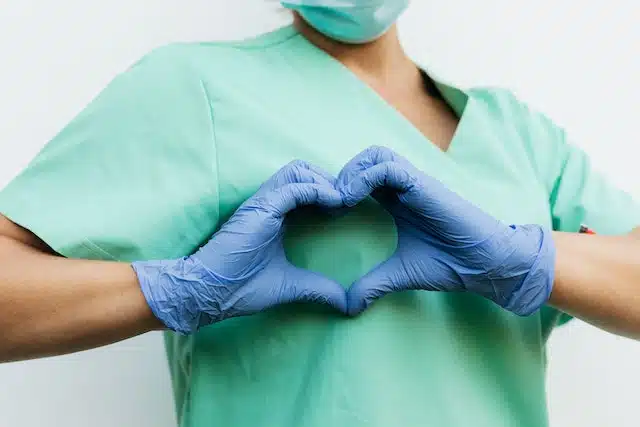 nurse with a heart hand-sign - featured image