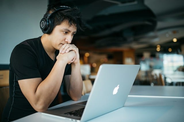 guy with headsets in front of a laptop