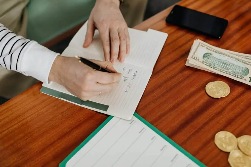 person writing on notebook